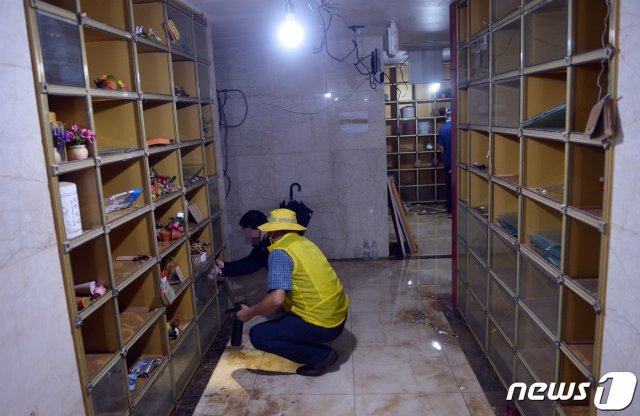 집중호우로 광주 영산강 인근에 있던 S추모관 내 유골함 1800여기가 침수피해를 당한 가운데 지난해 8월10일 한 유가족이 지하 1층에서 물에젖은 유골함을 꺼내고 있다.2020.8.10/뉴스1 © News1 DB