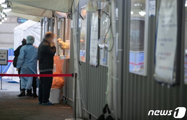 서울 중구 서울역광장에 마련된 임시선별진료소를 찾은 시민들이 검체검사를 받고 있다. 2021.1.26 © News1
