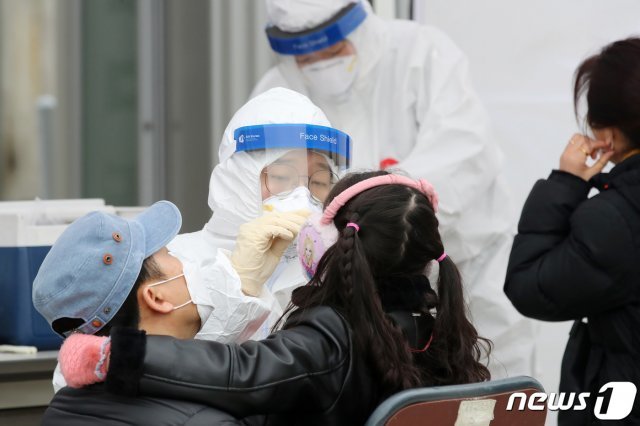 28일 경북 안동시보건소에 마련된 선별진료소에서 어린이를 동반한 가족이 신종 코로나바이러스 감염증(코로나19) 진단검사를 받고 있다. 이날 안동은 전날보다 기온이 떨어져 추운 날씨를 보였다. 2021.1.28 © News1