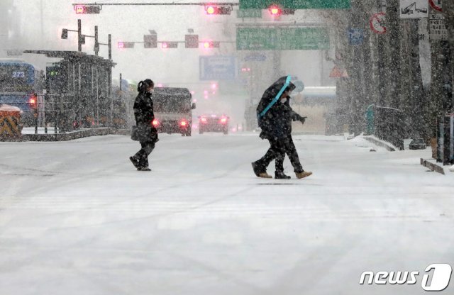 서울 종로구 일대에서 시민들이 내리는 눈을 피해 발걸음을 옮기고 있다. 뉴스1