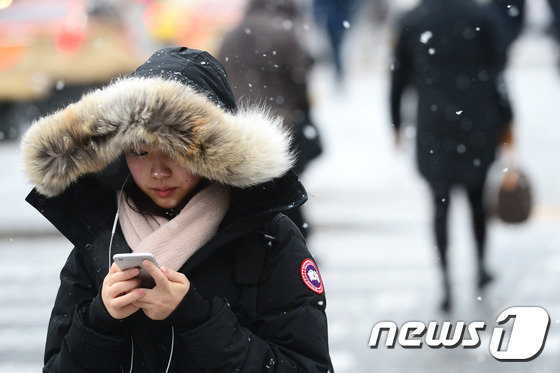 지난 2016년 1월26일 오전 서울 광화문네거리를 지나는 시민들이 내리는 눈을 맞으며 출근길을 서두르고 있다. 2016.1.26/뉴스1 © News1