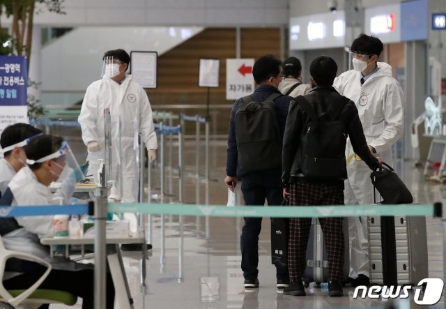 인천국제공항 제2터미널 입국장에서 입국자가 방역 당국의 안내를 받고 있다. 2020.12.31 © News1