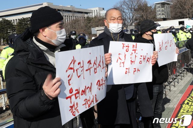 강제집합금지5개업종 비상대책위원회 회원들이 8일 오후 서울 영등포구 여의도 국회 앞에서 ‘’형평성 없는 장기간 집합금지 업종 해제 및 손실보상 기자회견‘’에서 혈서를 쓰고 정부의 신종 코로나바이러스 감염증(코로나19)방역 대책을 규탄하고 있다. 2021.2.8/뉴스1