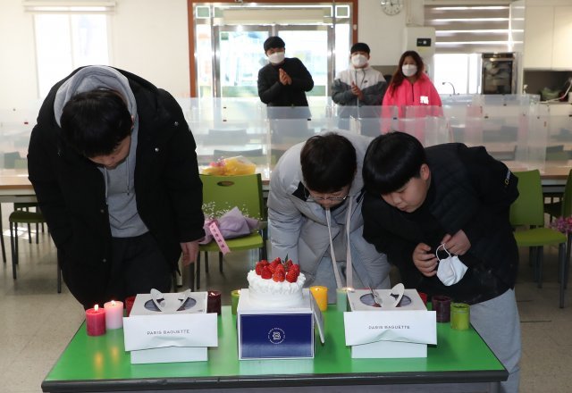 학교에서 준비한 케익과 촛불. 졸업생들이 촛불을 끄고있다.