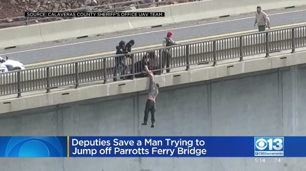 46m 다리 위 난간에서 뛰어내린 남성을 경찰이 구조하고 있다. CBS 뉴스 방송 캡처