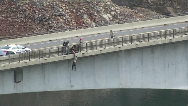 46m 다리 위 난간에서 뛰어내린 남성을 경찰이 구조하고 있다. 캘러베라스 카운티 보안관실 제공