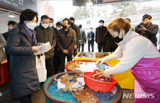 문재인 대통령과 부인 김정숙 여사가 10일 오전 인천 남동구 소래포구 전통어시장에서 문어를 구입하고 있다. 문 대통령 내외는 일회용 용기 사용 자제를 위해 상품을 담을 용기를 지참했다. 뉴시스