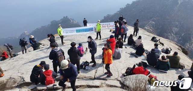 설 명절 연휴 첫날인 11일 북한산 백운대에서 국립공원 직원들과 산악안전봉사단원들이 신종 코로나바이러스 감염증(코로나19) 확산 방지를 위한 거리두기 캠페인을 하고 있다.(북한산국립공원 산악안전봉사단 제공) 2021.2.11/뉴스1