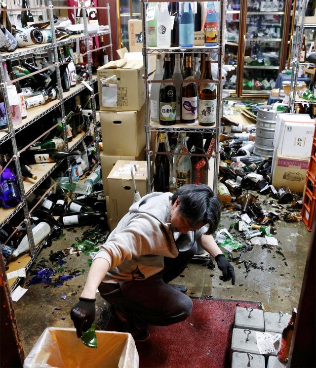 일본 후쿠시마 앞바다에서 리히터 규모 7.3의 강진이 발생한 13일 현지의 주류 판매점 주인이 지진으로 부서진 병들을 치우고 있다. 스가 요시히데 총리는 14일 “향후 일주일 정도 여진에 주의해야 한다”고 당부했다. 후쿠시마=AP 뉴시스