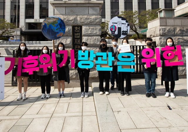 지난해 3월 13일 헌법소원 심판을 청구한 청소년들이 서울 종로구 헌법재판소 앞에서 ‘기후위기 방관은 위헌’이라는 손팻말을 들고 섰다. 청소년기후행동 제공