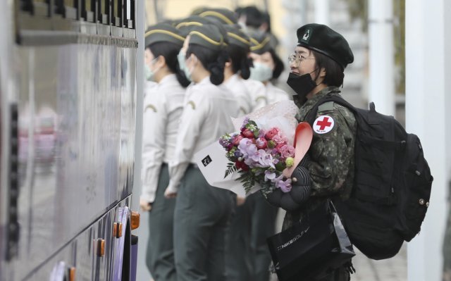 국군사관학교 60기 간호장교가   대전 유성구 국군간호사관학교에서 열린 졸업 및 임관식을 마친 뒤 대구지역의 신종 코로나바이러스 감염증(코로나19) 의료 지원을 위해 임관 축하 꽃다발을 든 채 버스에 탑승하고 있다. 사진제공 국방일보 국방사진 연구소