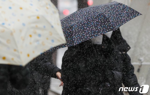 16일 중구 명동거리에서 우산 쓴 시민들이 걸어가고 있다. 2021.2.16/뉴스1 © News1