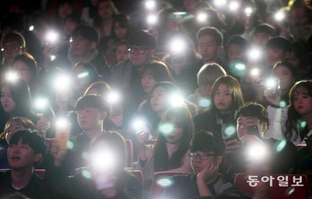 서울 서대문구 연세대 대강당에서 열린 총학생회 주최 신입생 오리엔테이션에 신입생들이 휴대폰을 불빛을 이용해 선배들의 공연에 호응하고 있습니다. 2018년 2월 13일