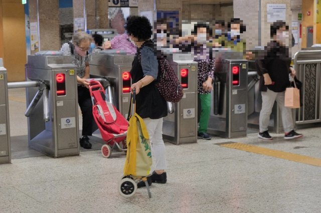 서울 한 지하철역에서 개표구를 통과하는 노인들. 일본 대중교통에도 경로우대는 있지만 대개 70세 이상에게 본인 부담의 일부를 지원해주는 형태를 띤다. 사진: 서울교통공사