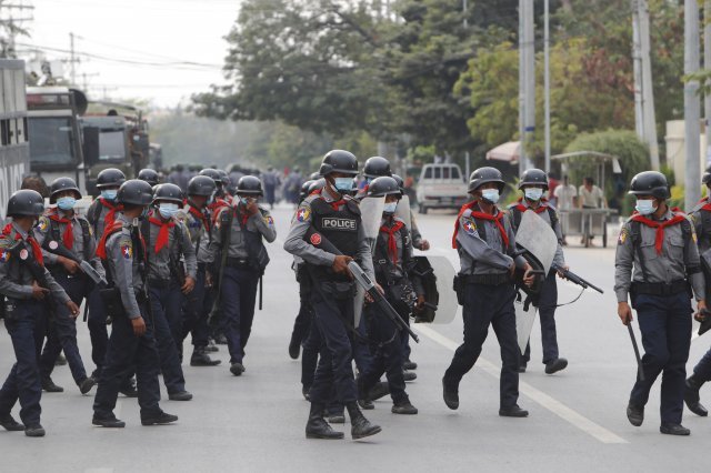 19일 미얀마 만달레이에서 무장경찰이 도로를 건너고 있다. AP뉴시스