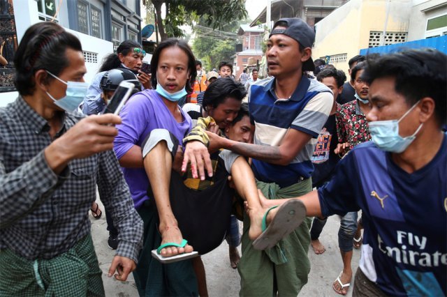 부상자 긴급 이송 미얀마 군경이 20일 미얀마 제2의 도시 만달레이에서 열린 쿠데타 항의 시위를 유혈 진압한 가운데 시민들이 부상자를 들어 옮기고 있다. 미얀마 시민들은 22일 전국적인 쿠데타 반대 총파업을 벌일 예정이다. 만달레이=AP 뉴시스
