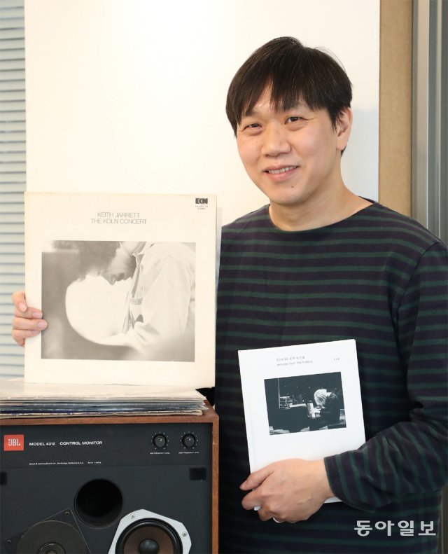 류진현 씨가 ECM 대표 명반인 키스 재럿의 ‘TheKoln Concert’ LP(왼쪽)와 신간 ‘ECM 50 음악 속으로’를 들어보였다. 김재명 기자 base@donga.com