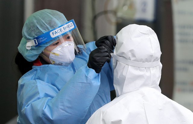 15일 서울 중구 서울역 광장에 마련된 임시선별진료소에서 의료진들이 방호복을 점검하고 있다. 뉴스1