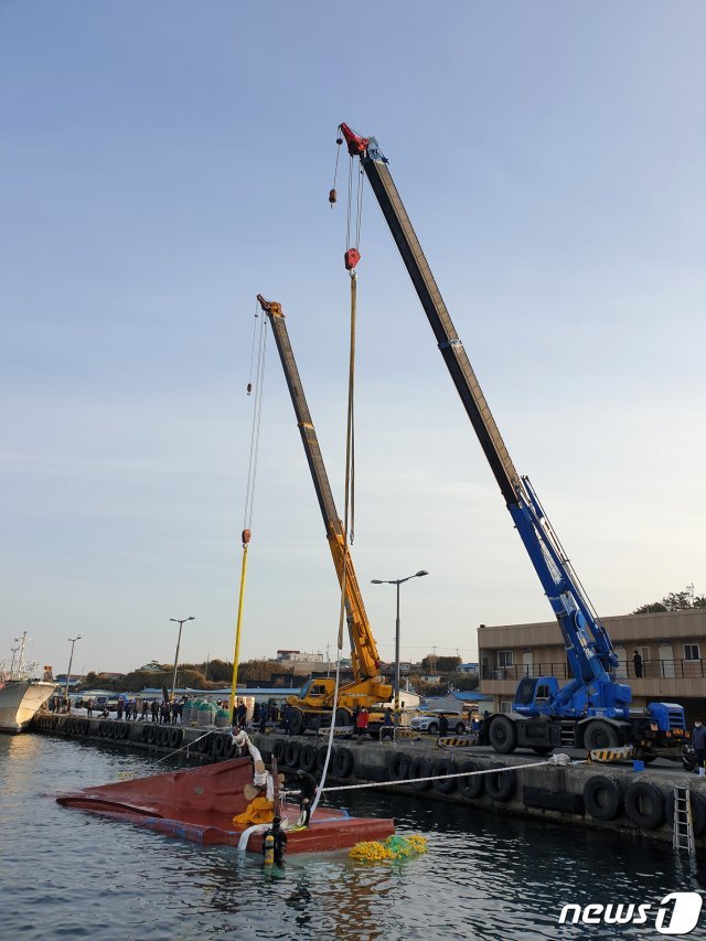 23일 경북 포항해양경찰서 구조대원들이 남구 구룡포 항으로 예인된 홍게잡이 어선 거룡호(9.77톤,구룡포선적)를 수면위로 부상 시키는 작업을 하고 있다. 거룡호는 19일 경주 감포 동방 42km해상에서 선장과 선원 6명을 태우고 항해 하던 중 사고를 당했다. 배에 타고 있던 선원 2명은 구조됐지만 베트남 선원 1명은 숨졌고 4명은 실종됐다. 2021.2.23 © News1