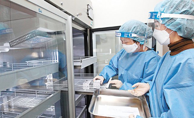 신종 코로나바이러스 감염증(코로나19) 백신 접종을 하루 앞둔 25일 서울 동작구 보건소에서 방역당국 관계자들이 영국 아스트라제네카의 코로나19 백신을 보관용 냉장고에 넣고 있다. 동작구청 제공