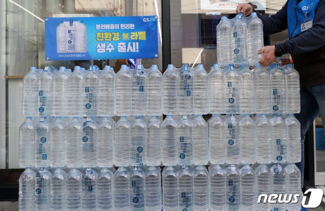 음료 업계에 상표띠(라벨)를 부착하지 않는 ‘라벨 프리’ 열풍이 뜨거운 가운데 23일 서울의 한 GS25 편의점에서 직원이 무(無)라벨 생수 ‘유어스DMZ맑은샘물 번들(6입) 제품을 정리하고 있다. GS25가 업계 최초로 판매를 시작한 이 제품은 개별 용기에 라벨을 부착하지 않고, 6입 번들을 포장하고 있는 패키지에 브랜드와 표시사항을 표기했다. 개당 0.8g의 비닐이 사용된 개별 상품의 라별을 제거하는 이번 활동을 통해 연간 약 50톤 이상의 폐기물 감소 효과가 있을 것으로 예상된다. 2021.2.23 © News1