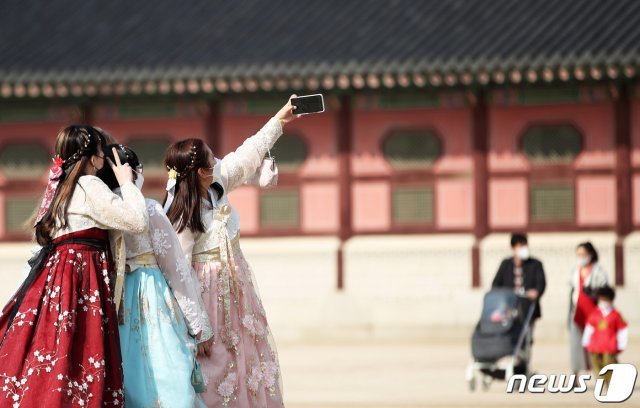 지난달 13일 오후 서울 종로구 경복궁에서 한복을 곱게 차려입은 시민들이 기념사진을 찍고 있다. 2021.2.13 © News1