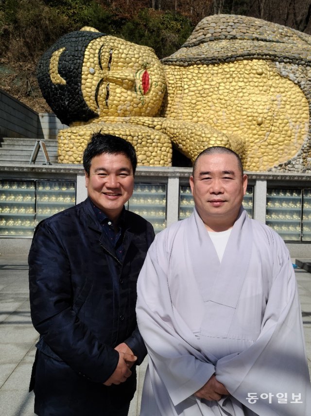 ‘사랑의 밥차’ 채성태 이사장(왼쪽)과 청계사 주지 성행 스님. 뒤에 보이는 와불(臥佛·누워 있는 부처)은 길이 15m, 높이 2m로 둥글둥글한 몽돌로 조성됐다. 의왕=김갑식 문화전문기자 dunanworld@donga.com