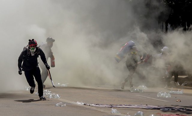 반 쿠데타 시위대가 4일 미얀마 양곤에서 경찰이 발사 한 최루탄을 피해 달아나고 있다. AP 뉴시스