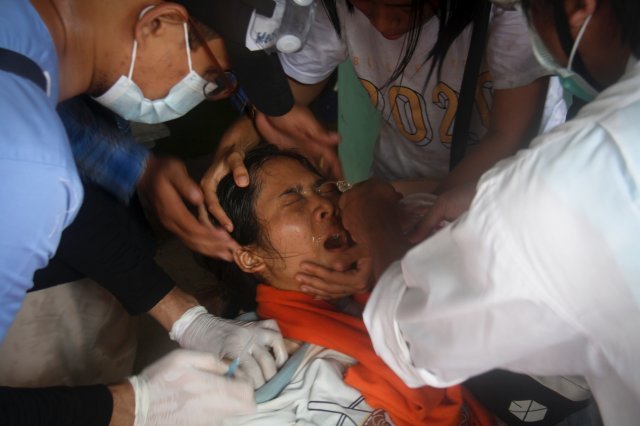 2일 미얀마 양곤에서 열린 반 쿠데타 시위에서 부상을 입은 한 여성이 의료진의 치료를 받고 있다. AP 뉴시스