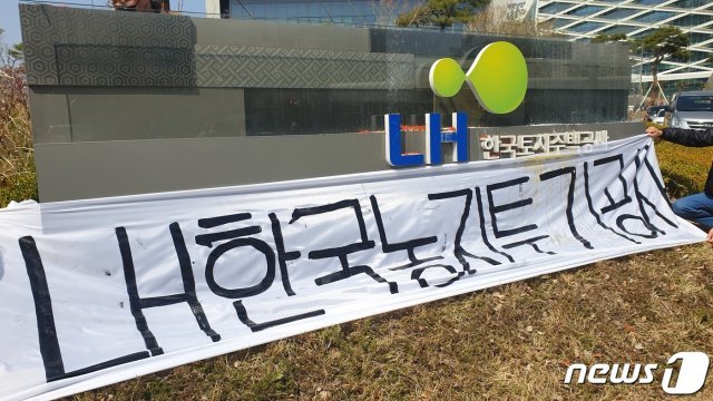 경남 농업인들이 8일 LH 진주 본사를 찾아가 표지석에 ‘LH한국투기공사’라고 쓰여진 가림막을 걸었다.© 뉴스1