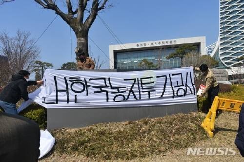 전농부경연맹이 8일 경남 진주 한국토지주택공사 본사 앞에 ‘한국농지투기공사’라고 적힌 현수막을 걸고있다. 뉴시스