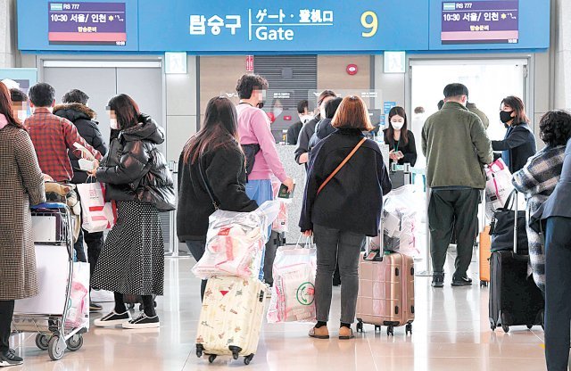 지난달 20일 에어서울 무착륙 관광 비행 이용객들이 양손에 면세품 쇼핑백과 여행가방을 든 채 탑승구 앞에서 대기하고 있다. 에어서울 제공