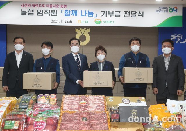 9일 서울 중구 농협중앙회 본관에서 이성희 농협중앙회장(사진 왼쪽에서 세번째), 김용택 전국금융산업노동조합 NH농협지부 위원장(맨오른쪽), 김동혁 NH농협중앙회노동조합 위원장(맨왼쪽)이 농협 임직원 함께 나눔 기부금으로 마련한 우리 농산물 꾸러미를 파견 및 용역 근로자에게 전달하고 있다. 농협 제공