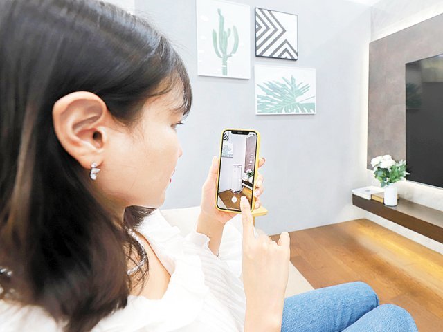롯데하이마트 모바일 앱에서 AR 서비스를 구동해 가전을 배치해보고 있다.