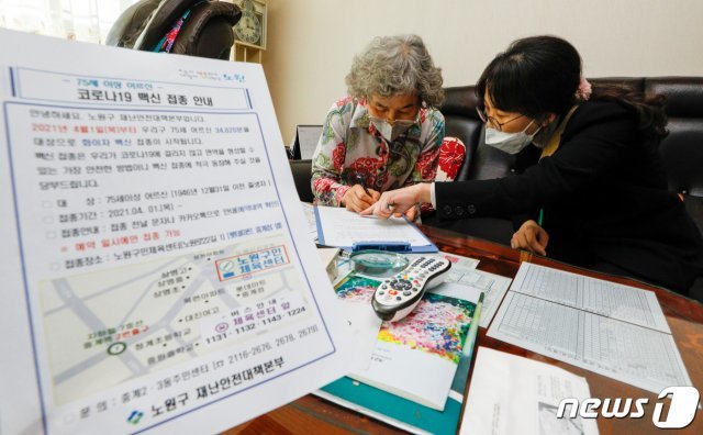 노원구청 직원이 19일 서울 관내 아파트를 찾아 이정자(78)씨로부터 신종 코로나바이러스 감염증(코로나19) 접종 동의 서명을 받고 있다.  2021.3.19/뉴스1 © News1 안은나 기자