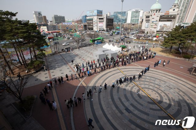 19일 오전 서울 구로역광장에 마련된 임시 선별진료소를 찾은 시민들과 외국인들이 검체 검사를 받기 위해 줄을 서 있다. 2021.3.19/뉴스1 © News1