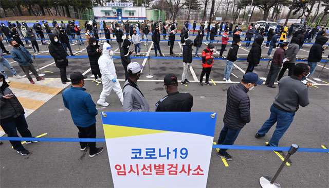 외국인 근로자 ‘장사진’ 21일 경기 안산시 단원구 외국인주민지원본부 인근에 설치된 임시 선별검사소에서 외국인 근로자 등 시민들이 신종 코로나바이러스 감염증 진단 검사를 받기 위해 줄지어 기다리고 있다. 안산=뉴시스