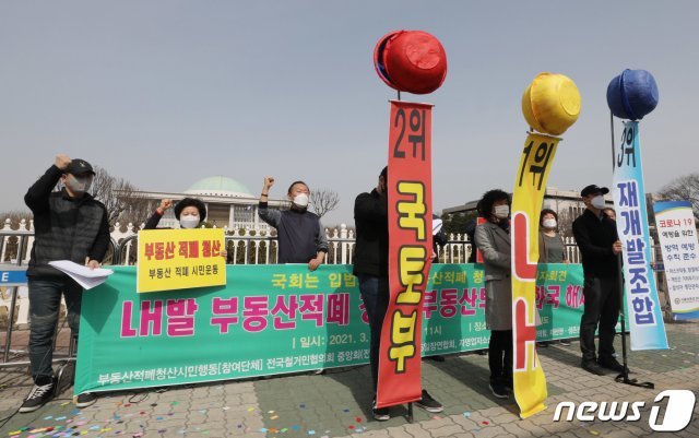 부동산적폐청산시민행동 회원들이 19일 서울 여의도 국회 앞에서 부동산적폐 3적 발표 기자회견을 갖고 적폐 청산을 촉구하고 있다. 2021.3.19/뉴스1 © News1