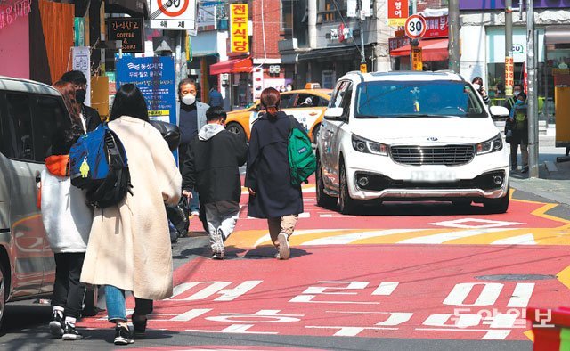 아슬아슬한 하굣길… 엄마와 함께 23일 서울 서대문구의 한 초등학교 앞에서 수업을 마친 학생들과 마중을 나온 
학부모들이 차량과 뒤엉켜 도로를 위태롭게 지나고 있다. 25일 ‘민식이법’ 시행 1년을 앞두고 불법 주정차·보차도 혼용도로 등 
어린이보호구역(스쿨존) 내 교통안전 강화가 시급하다는 지적이 나온다. 홍진환 기자 jean@donga.com