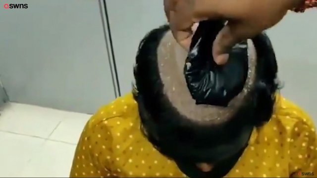 경찰이 밀수업자가 정수리에 숨긴 금과 현금을 발견한 당시 상황을 재연하는 모습. 유튜브 채널 SWNS 갈무리