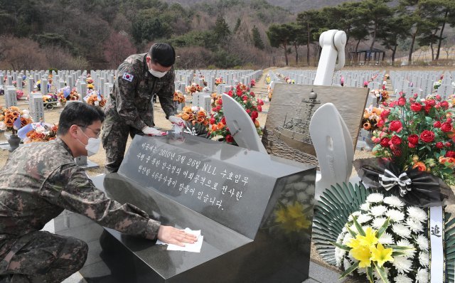 천안함 폭침 11주기를 이틀 앞둔 24일 대전 유성구 국립대전현충원 천안함 46용사 묘역에서 해군본부 장병들이 순직자들의 묘비를 닦고 있다. 홍진환 기자 jean@donga.com