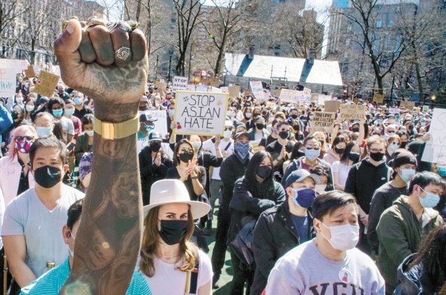 미국 뉴욕 맨해튼 차이나타운의 한 공원에서 21일(현지 시간) 아시아계 미국인에 대한 증오범죄에 항의하는 시위대가 행진하고 있다. \'아시아계 증오를 멈추라\' 등의 구호가 쓰인 손 팻말이 보인다. 뉴욕=AP 뉴시스