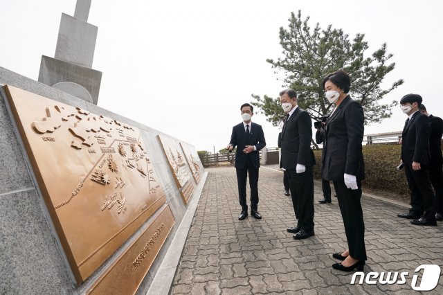 문재인 대통령과 김정숙 여사가 26일 오후 경기 평택 해군2함대 사령부에서 열린 제6회 서해수호의날 기념식에 앞서 제2연평해전 전적비에 참배한 후 제1연평해전 승전비 설명을 듣고 있는 모습을 탁현민 의전비서관(뒤)이 지켜보고 있다. © News1