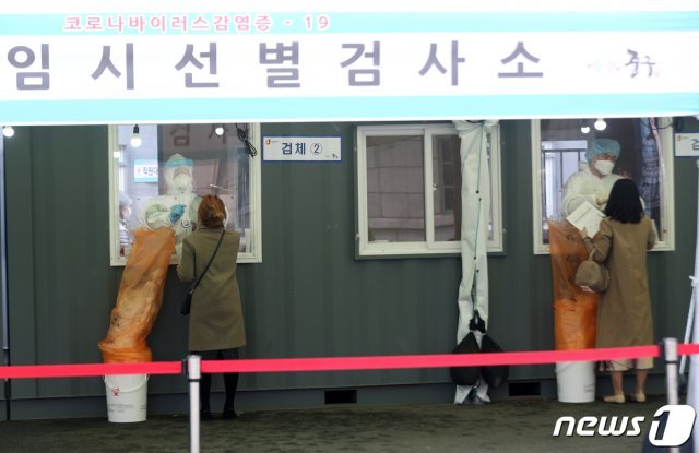 26일 서울 중구 서울역광장에 마련된 신종 코로나바이러스 감염증(코로나19) 임시선별진료소에서 시민들이 검사를 받고 있다. 뉴스1