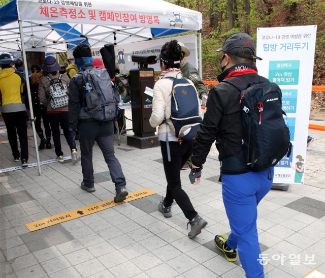 지난해 4월 북한산을 찾은 등산객들이 입장 전 체온 측정과 방명록 작성을 위해 줄을 서 있다. 동아일보DB