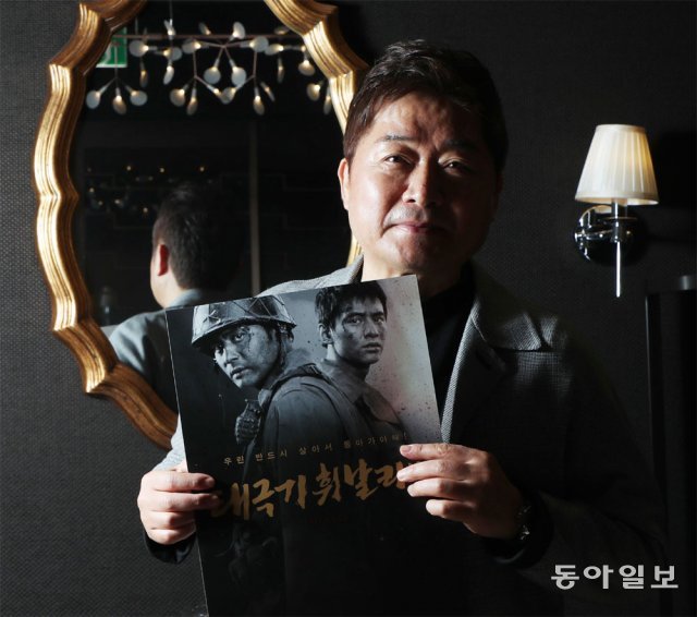 19일 서울 CGV 용산아이파크몰에서 강제규 감독이 17년 만에 재개봉한 ‘태극기 휘날리며’의 포스터를 들어 보였다. 박영대 기자 sannae@donga.com