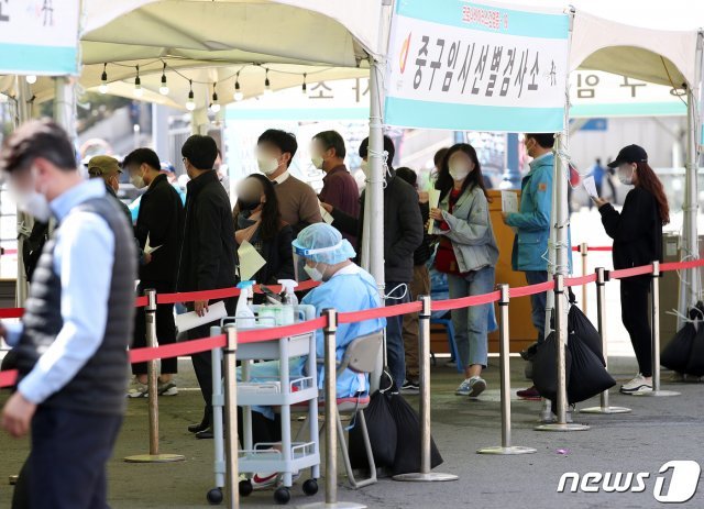 1일 오전 서울역 광장에 마련된 중구 임시선별진료소에서 시민이 검사를 받기 위해 줄지어 서 있다./뉴스1 © News1