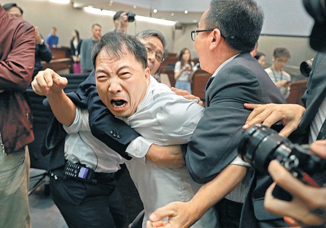 홍콩 야권 지도자 우치와이 전 민주당 대표(가운데)가 2019년 5월 입법회 의사당에서 홍콩 범죄인을 중국 본토로 송환할 수 있는 ‘송환법’ 제정에 반대하며 보안요원들과 몸싸움을 벌이고 있다. 홍콩=AP 뉴시스