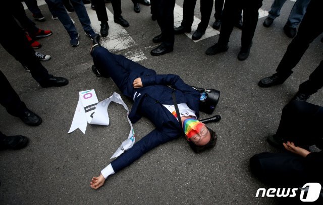 오태양 미래당 서울시장 후보가 2일 오후 서울 양천구 목동깨비시장 앞에서 열린 국민의힘 오세훈 서울시장 후보 선거유세장에서 본인의 선거운동을 하는 가운데 경찰의 제지로 바닥에 쓰러져있다. 2021.4.2/뉴스1 © News1