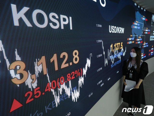 22일 오후 서울 영등포구 KB국민은행 여의도지점 스마트딜링룸에서 한 직원이 업무를 보고 있다. 이날 코스피 지수는 외국인과 기관의 쌍끌이 순매수에 힘입어 25.4포인트(0.82%)오른 3112.8로 장을 마감했다. 2021.4.2 © News1